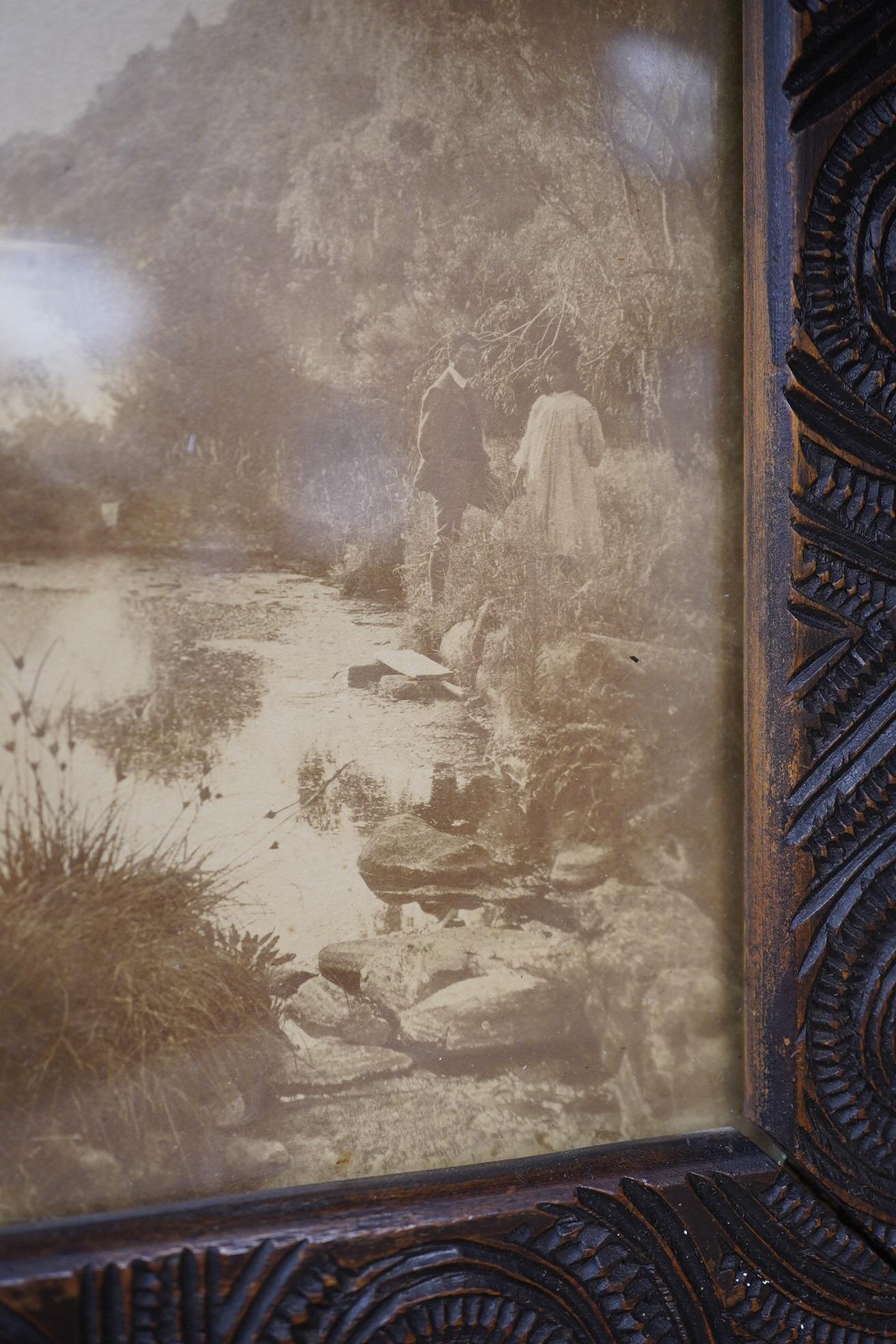 A pair of Maori carved wood photograph frames containing contemporary New Zealand photographs c.1900-10, carved in relief with rauponga lines and spirals, inset with contemporary albumen photos, depicting figures by Waik